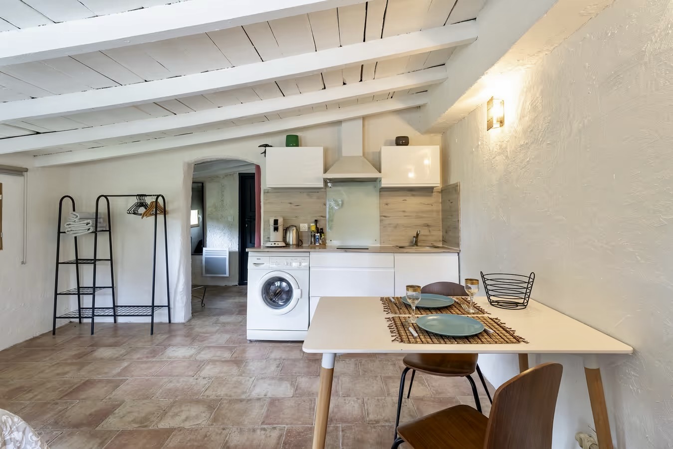 Le studio : coin cuisine et repas sous charpente blanche
