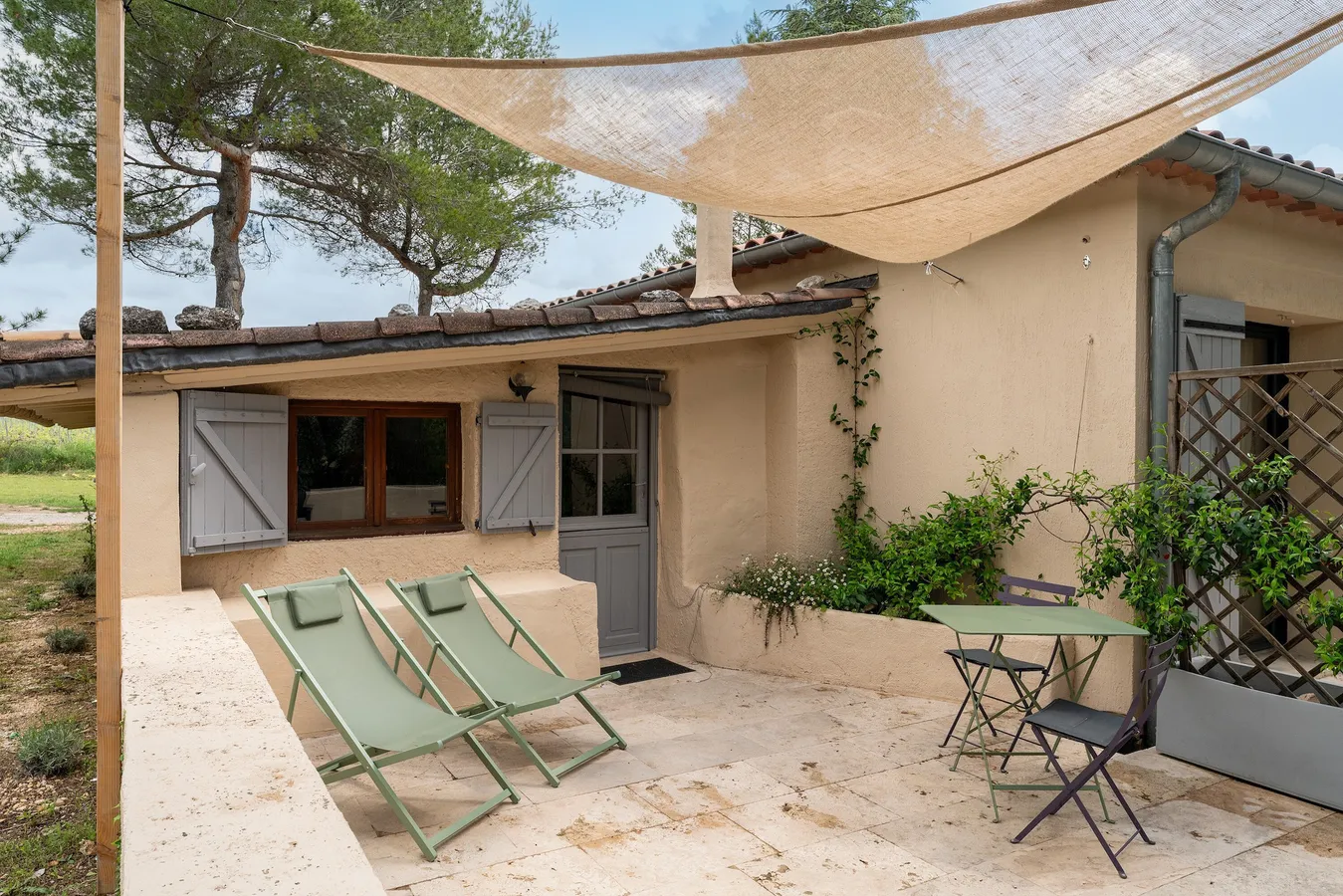 Terrasse privative avec transats sous la voile d'ombrage